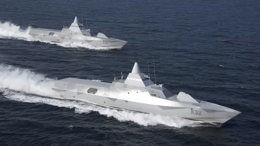 Two stealth warships sailing at high speed on open water.