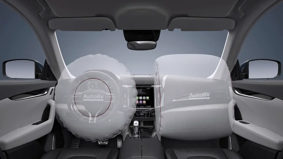 Car interior with deployed airbags on steering wheel and dashboard.