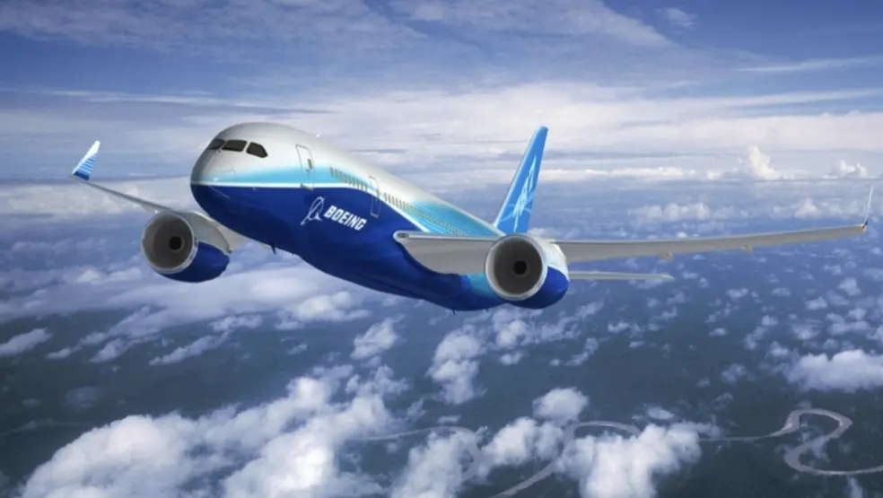 Airplane flying above clouds with blue and white livery, Boeing logo visible.