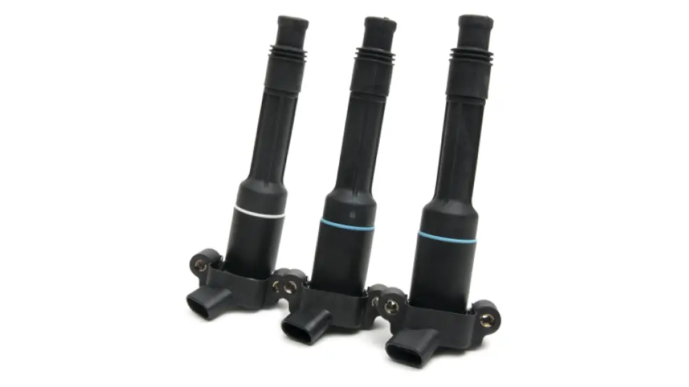 Three black ignition coils with colored bands on a white background.