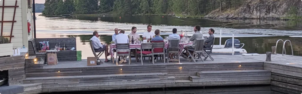 Lightness medarbetare sitter och äter på en brygga i Stockholms skärgård